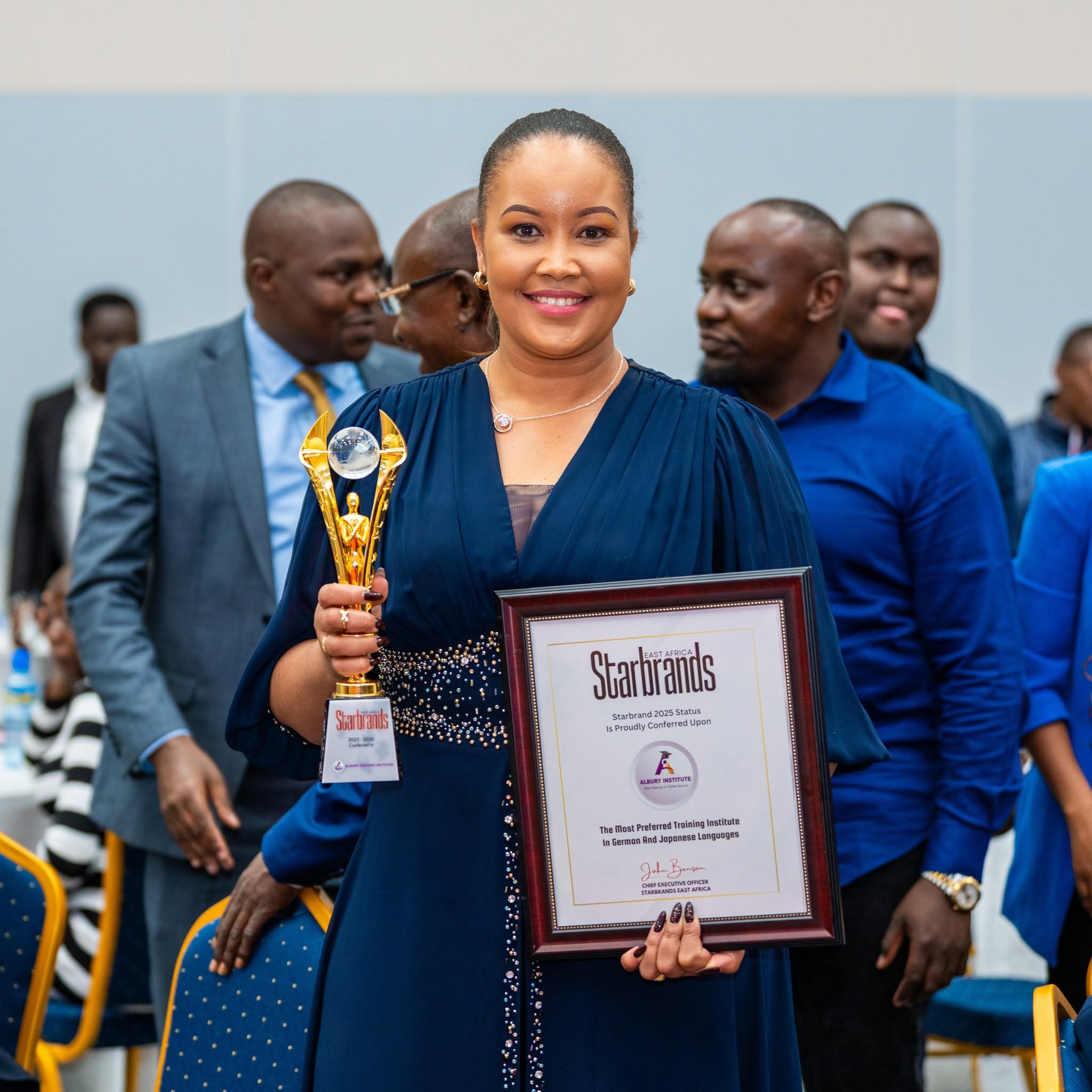 Honoree proudly holding golden statuette and Starbrands 2025 Status Certificate