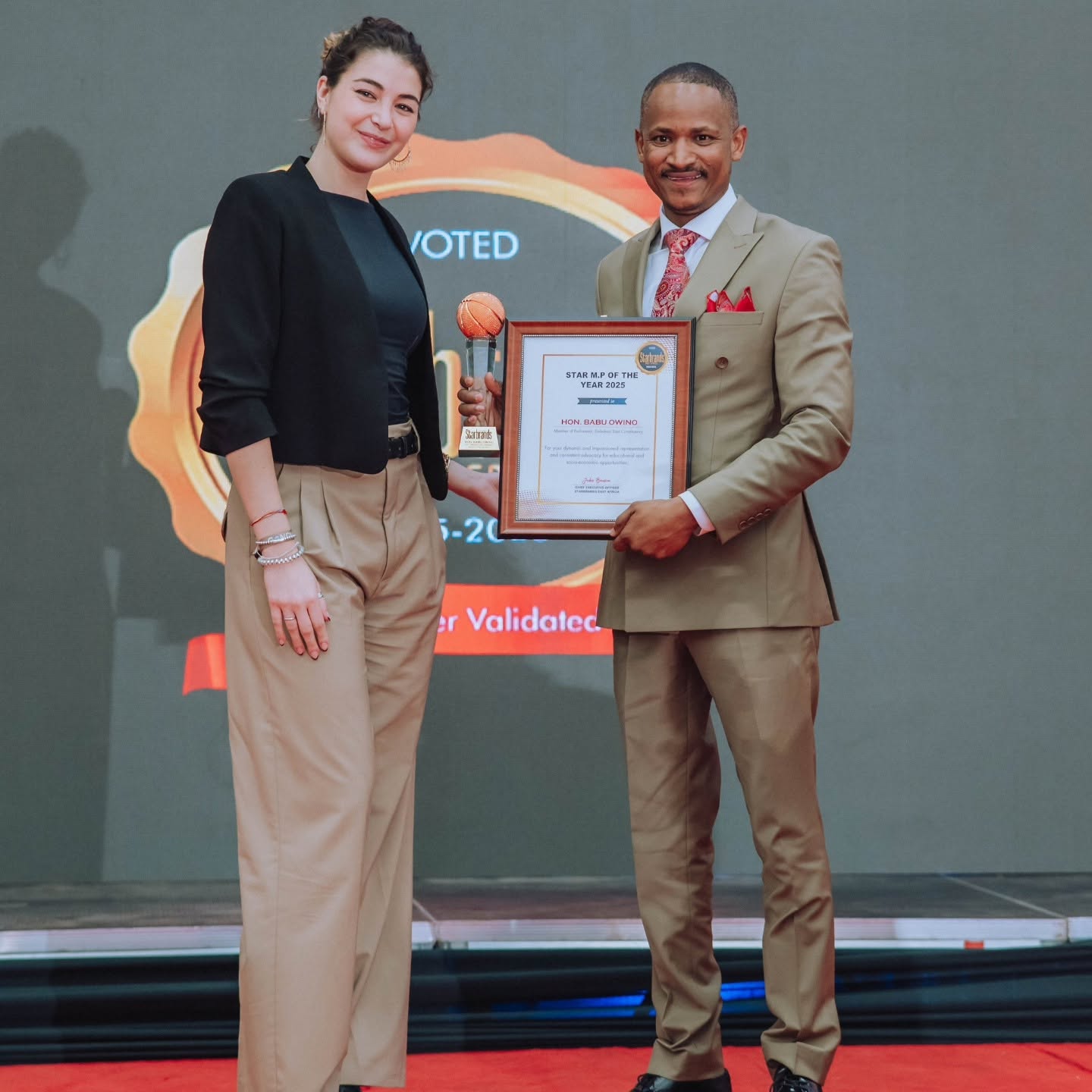 Hon. Babu Owino receiving award on stage from presenter