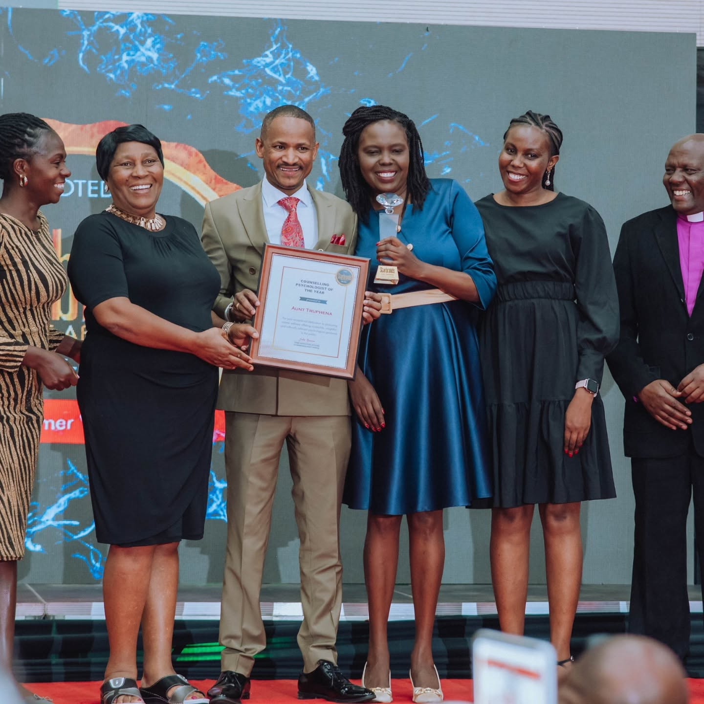 Aunt Truphena receiving award on stage with guests