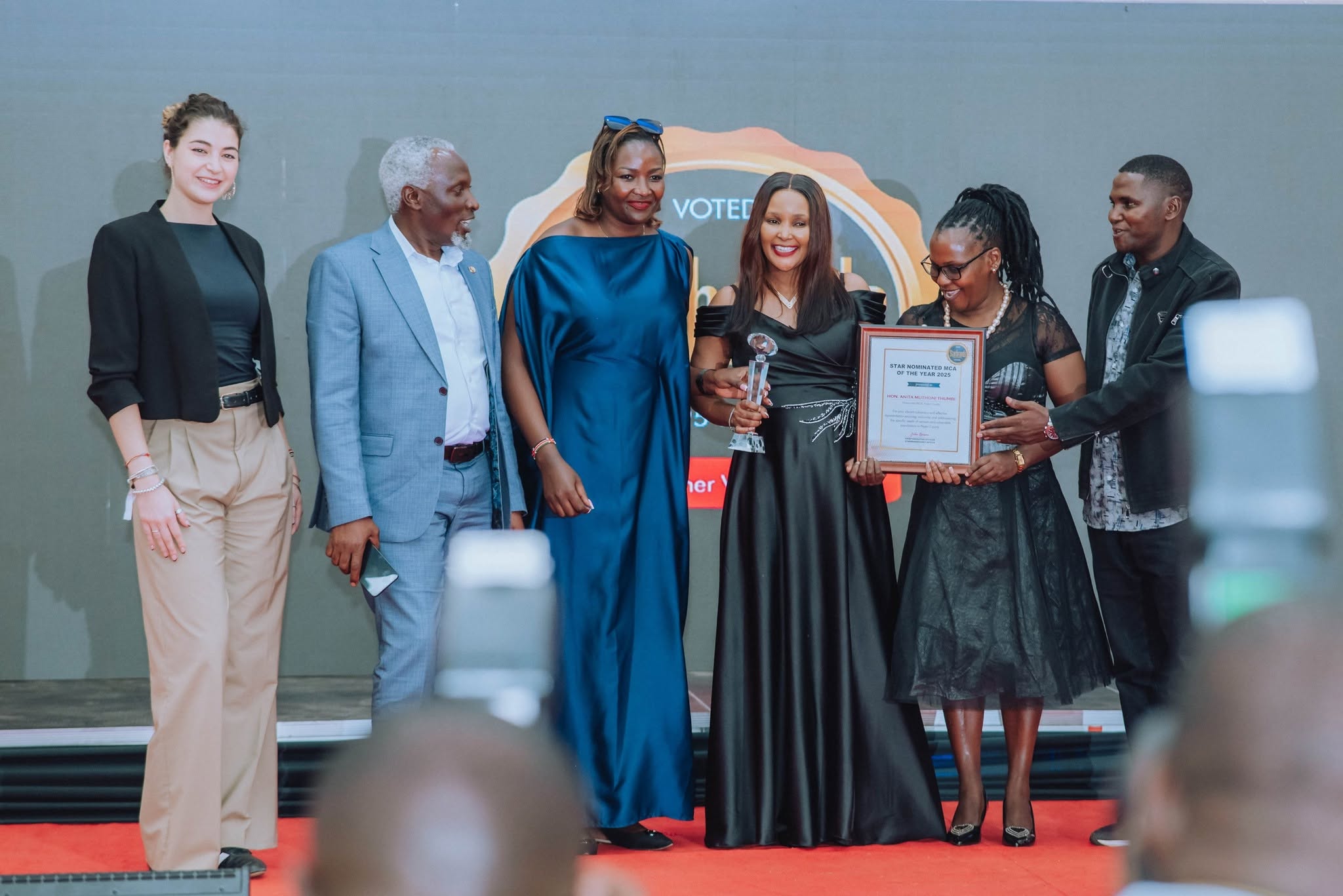Hon. Anita Muthoni Thumbi receiving award on stage